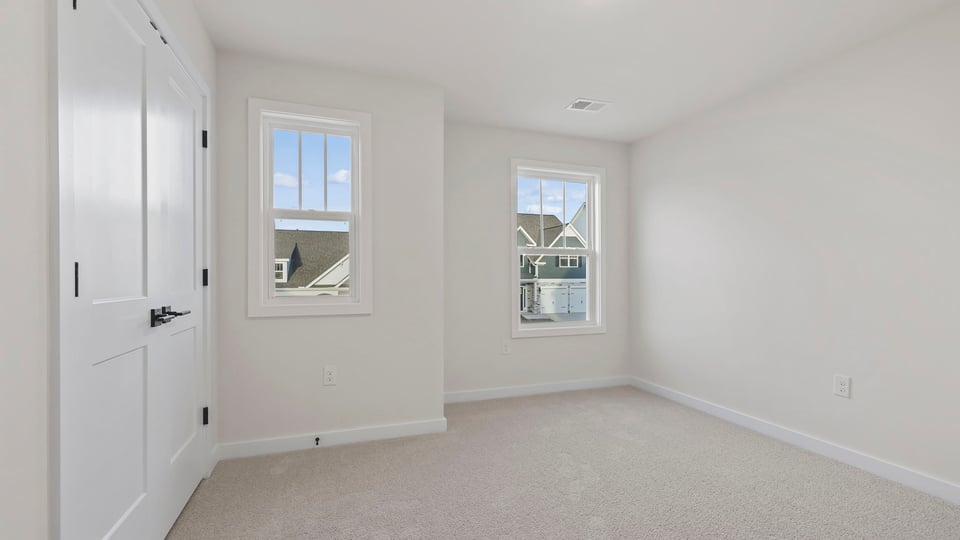 Bedroom with carpet and windows.