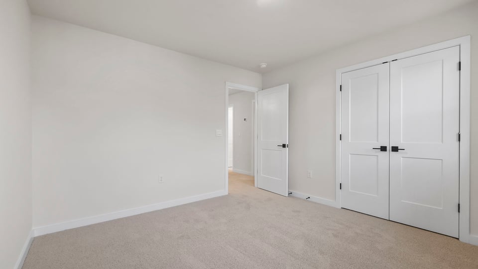 Bedroom with carpet and windows.