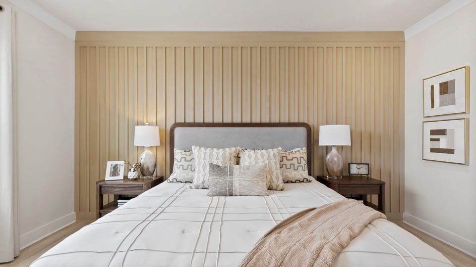 Primary bedroom with carpet and windows.