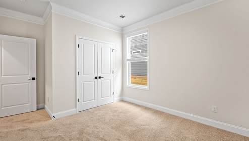 Bedroom with carpet and window.