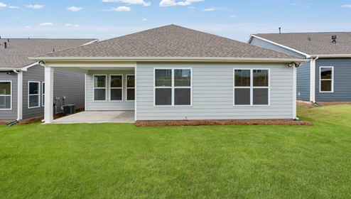 Back exterior of home with large backyard.