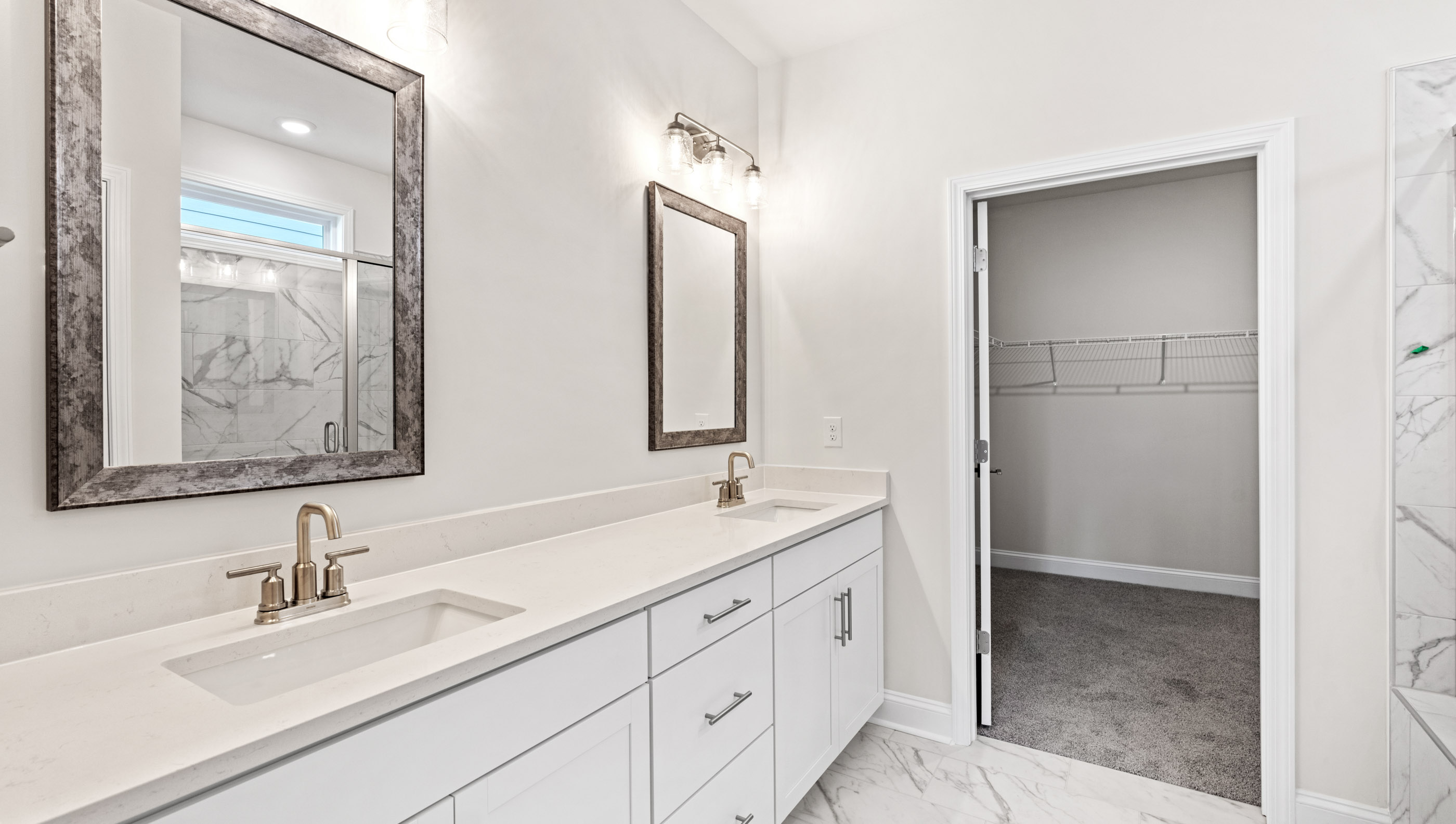 Primary bathroom with double vanity sinks and closet.