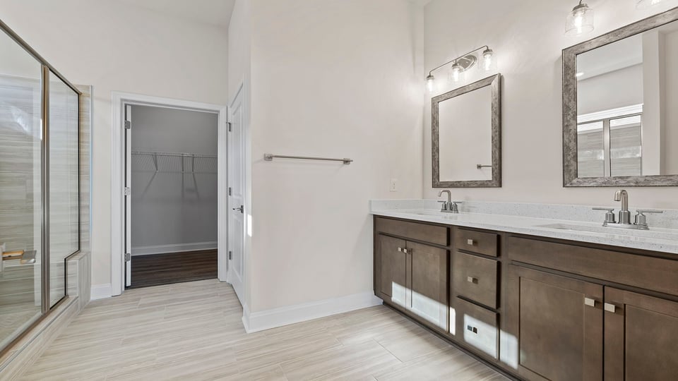 Primary bathroom with dual sink vanity and mirrors.