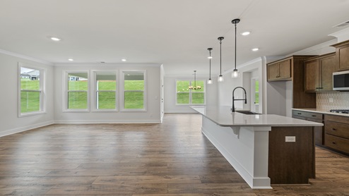 Living area with windows and kitchen view.