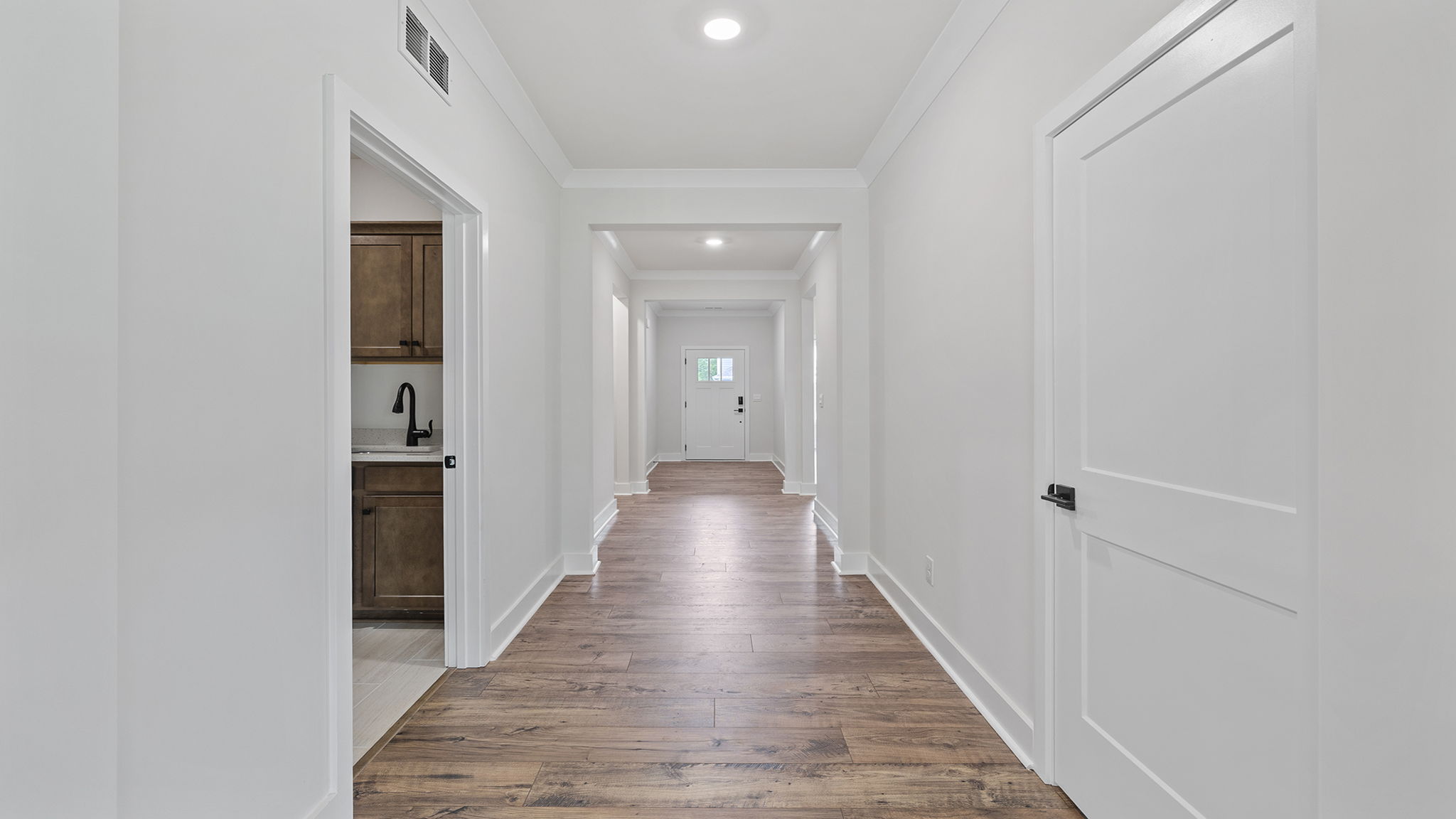 View of hallway toward the entrance and of hall bathroom.