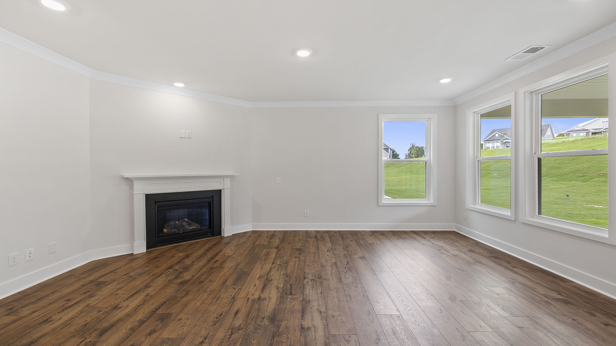 Family room with windows and gas log fireplace.