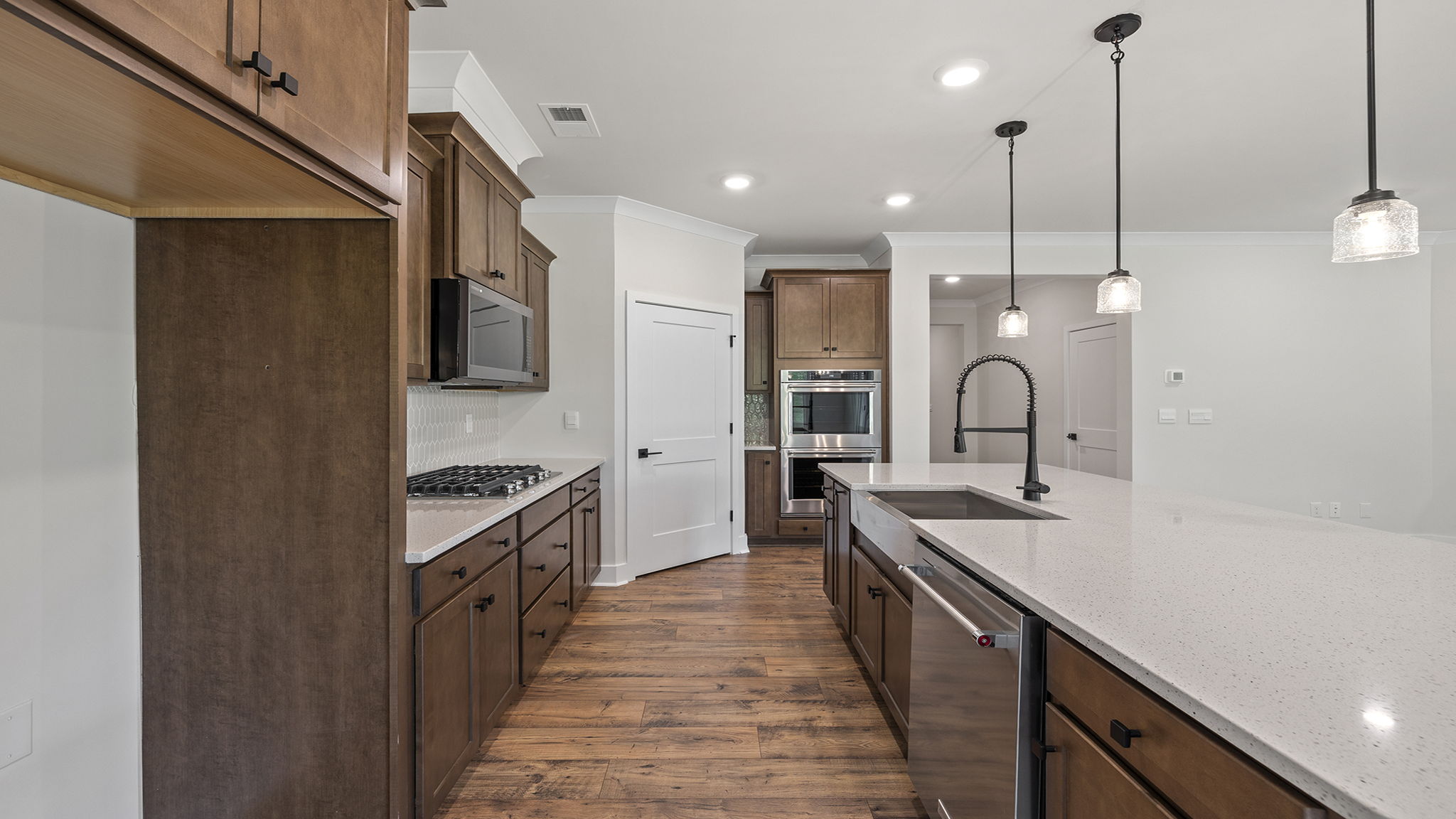 Kitchen with quartz countertops and pendulum lighting.