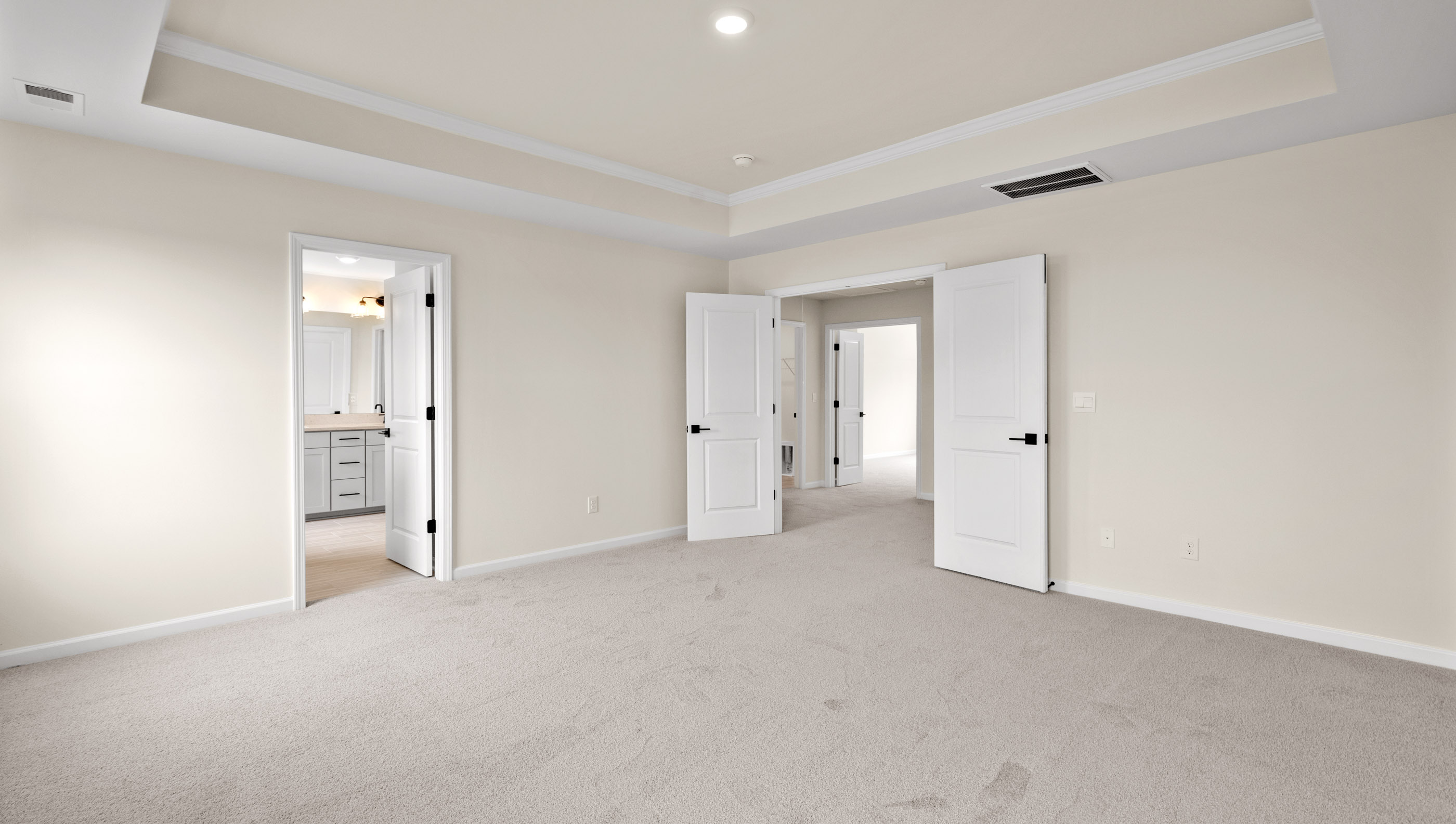 Primary bedroom with carpet and window.