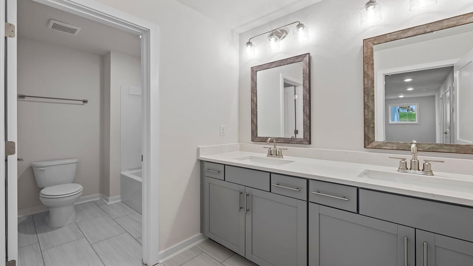 Primary bathroom with dual sink vanity and large walk-in shower.