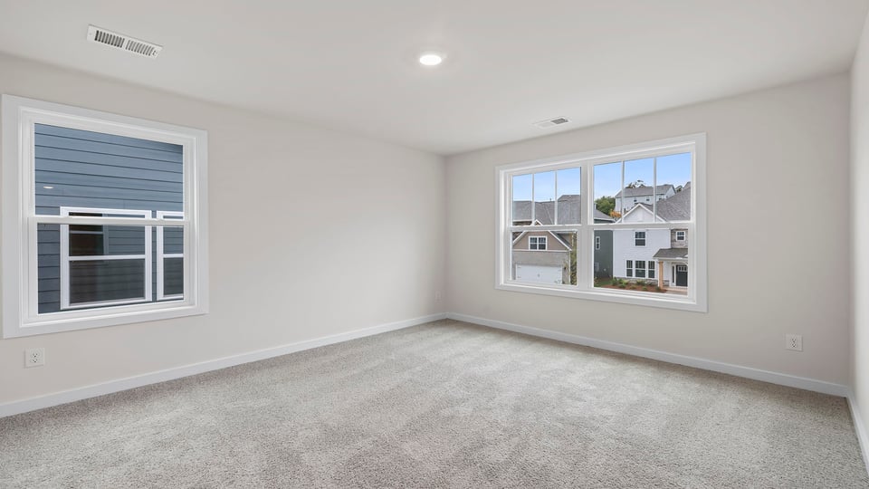 Bedroom with windows and carpet.