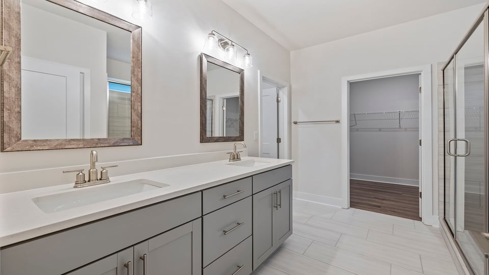 Primary bathroom with dual sink vanity and large walk-in shower.