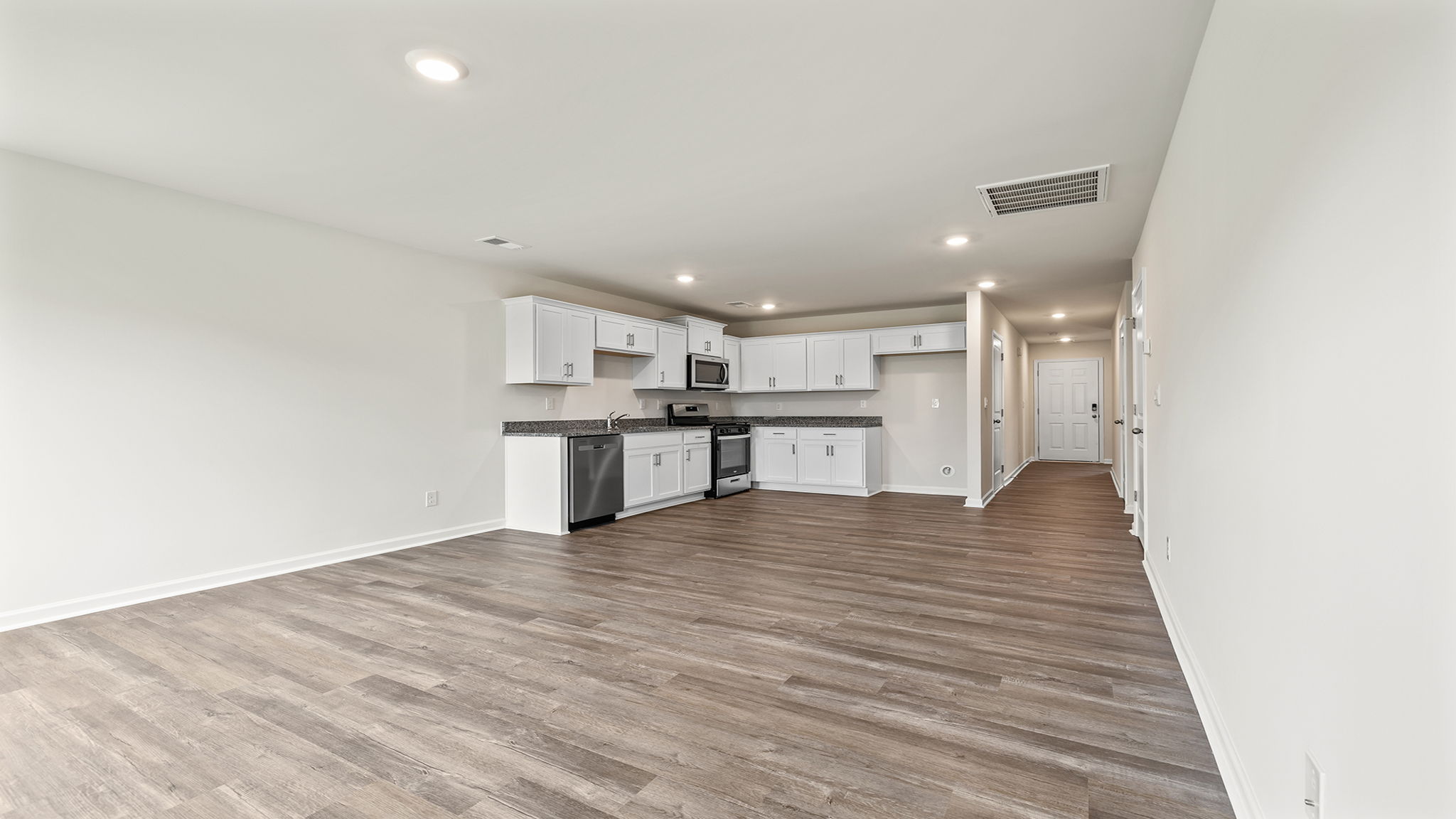 View from living area of kitchen and hallway to the entrance.