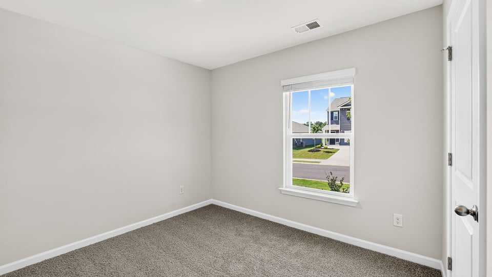 Bedroom with carpet and window.