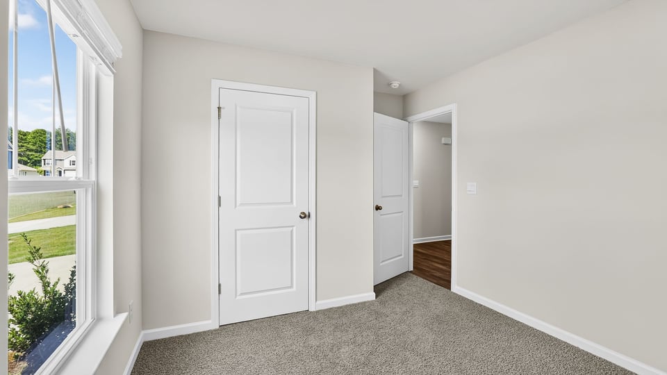 Bedroom with carpet and window.