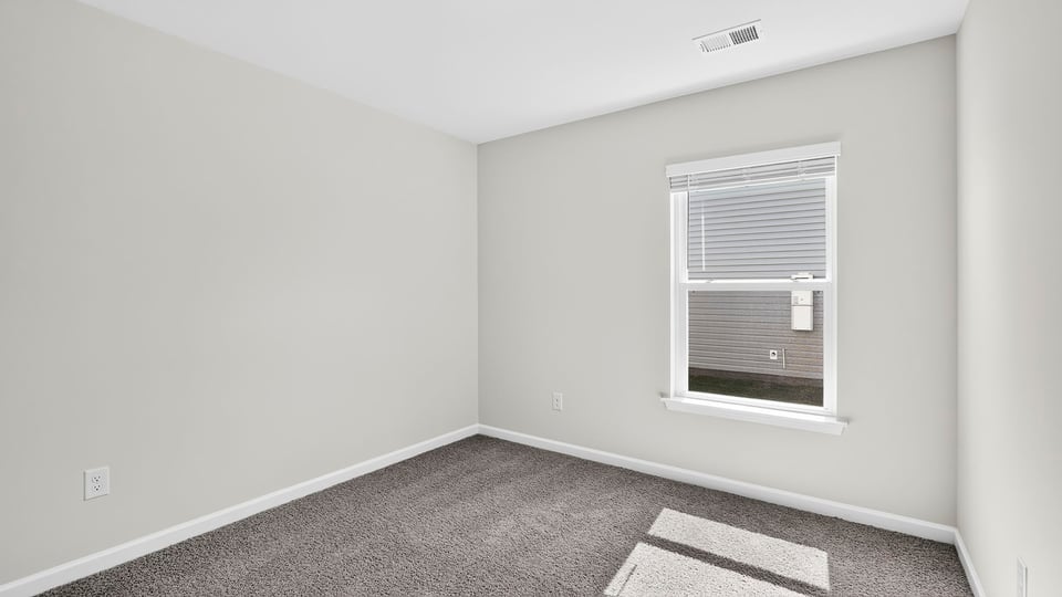 Bedroom with carpet and window.