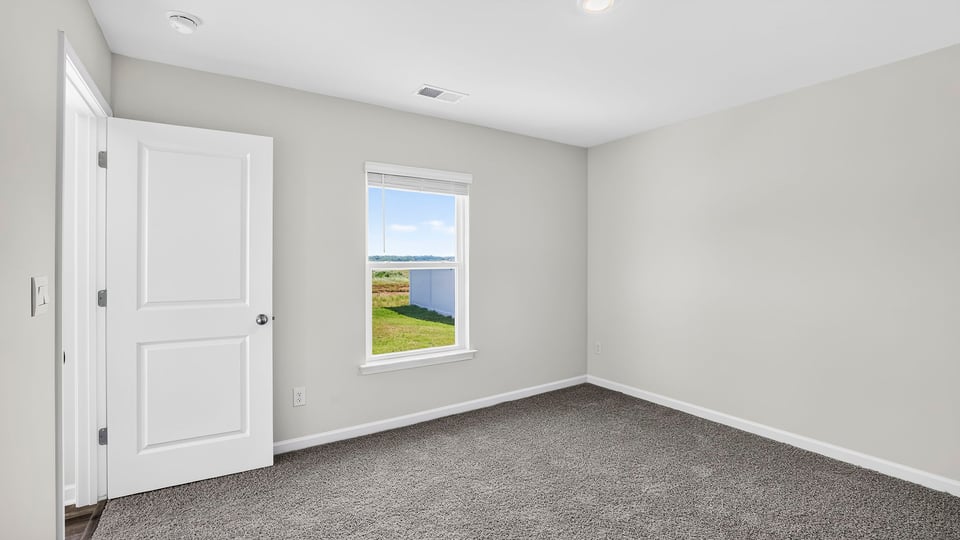 Bedroom with carpet and window.