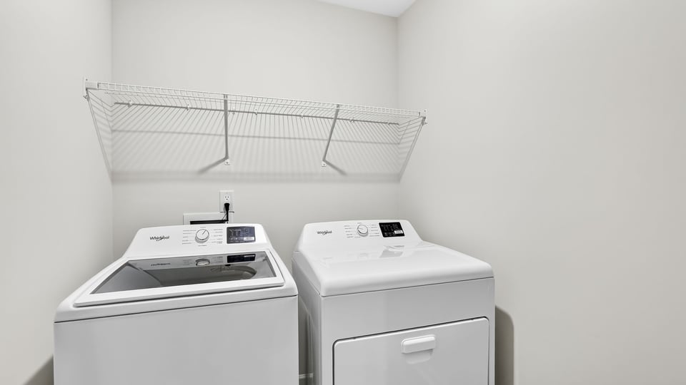 Laundry room with hanging storage racks.
