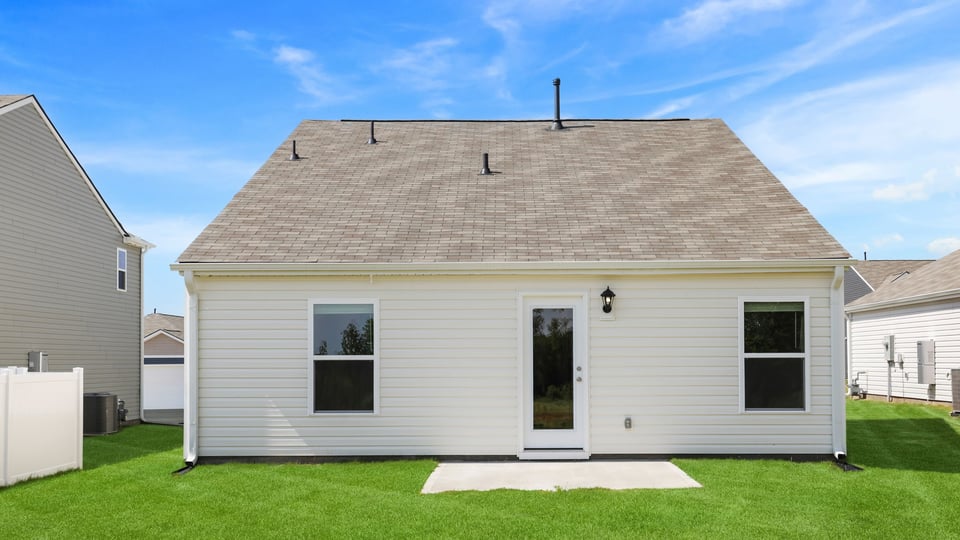 Back exterior of home with large backyard.