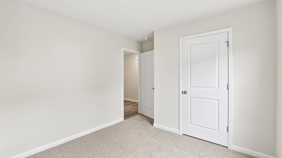 Bedroom with carpet and windows.
