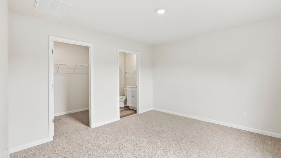 Bedroom with carpet and windows.