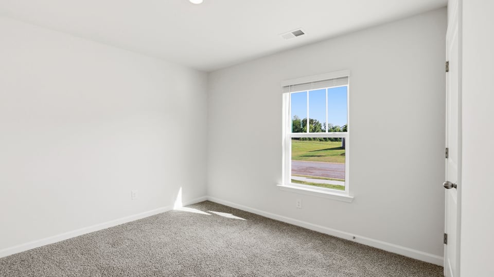 Bedroom with carpet and window.