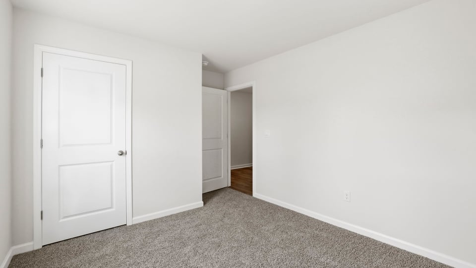 Bedroom with carpet and window.
