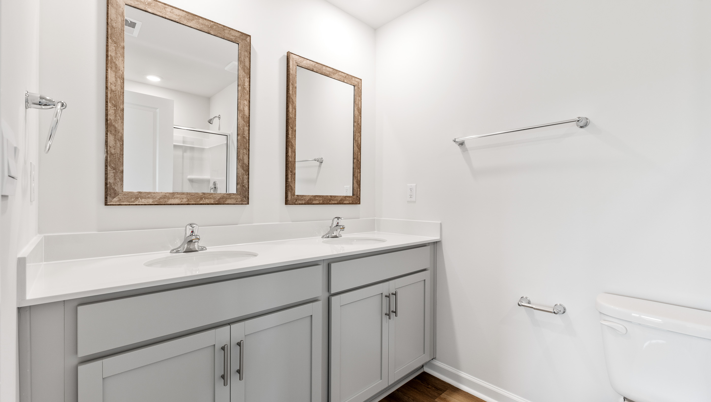 Primary bathroom with dual sink vanity and mirrors.