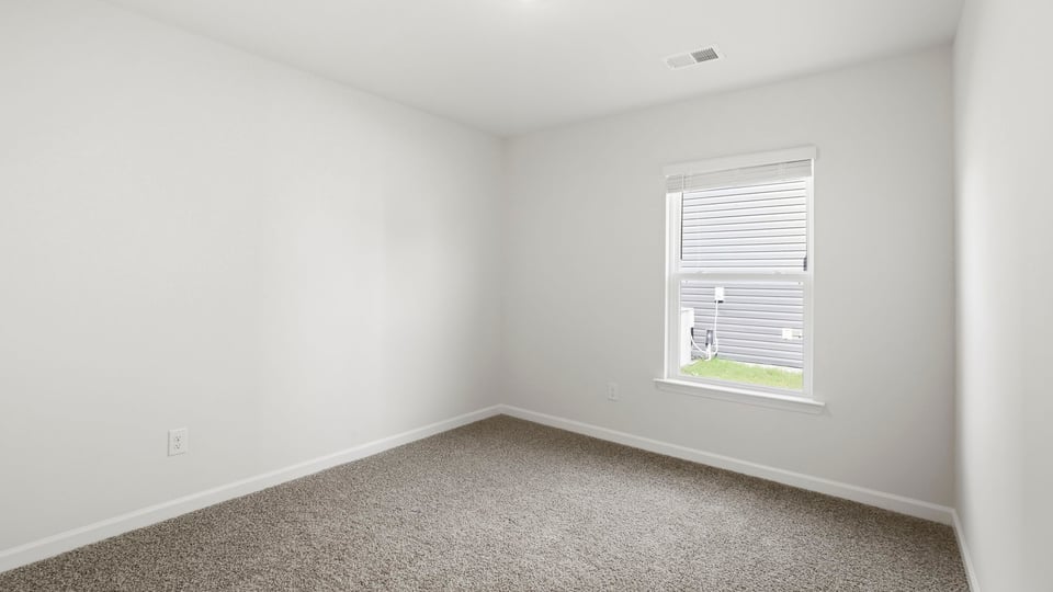 Bedroom with carpet and window.
