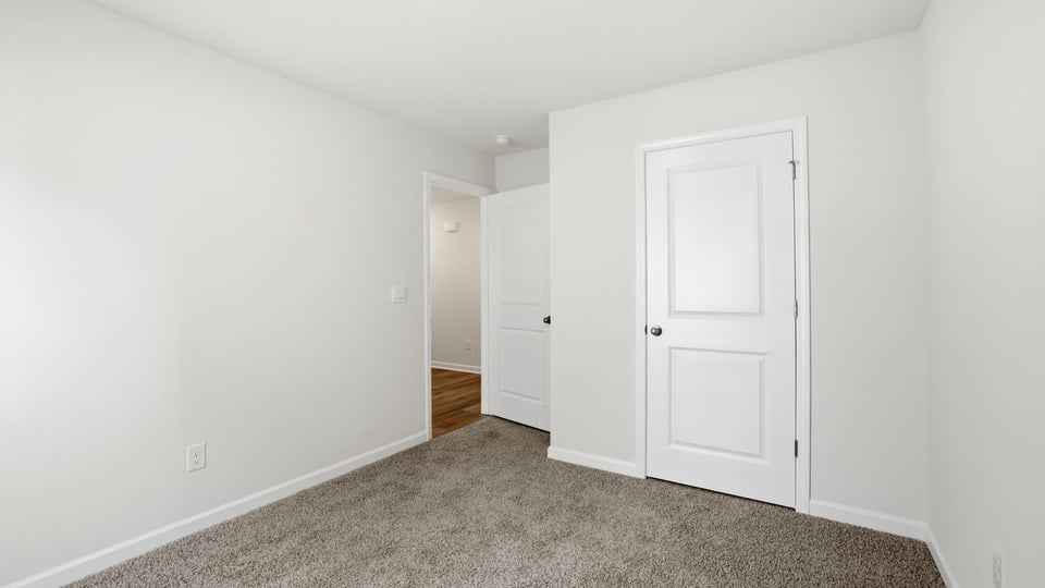 Bedroom with carpet and window.