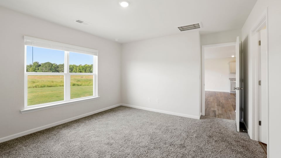 Bedroom with carpet and window.