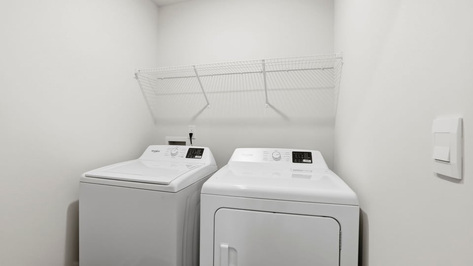 Laundry room with hanging shelves.