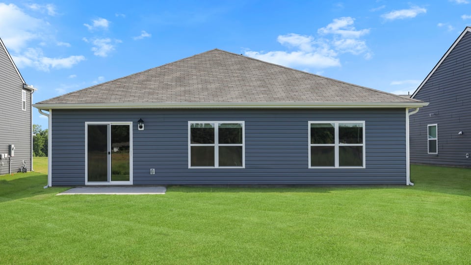 Back exterior of home with large backyard.