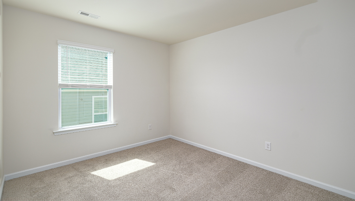 Bedroom with carpet and window.