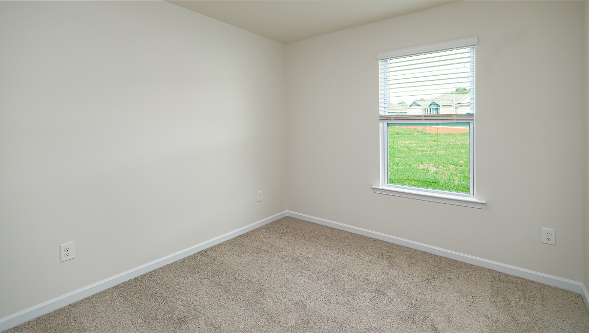 Bedroom with carpet and window.
