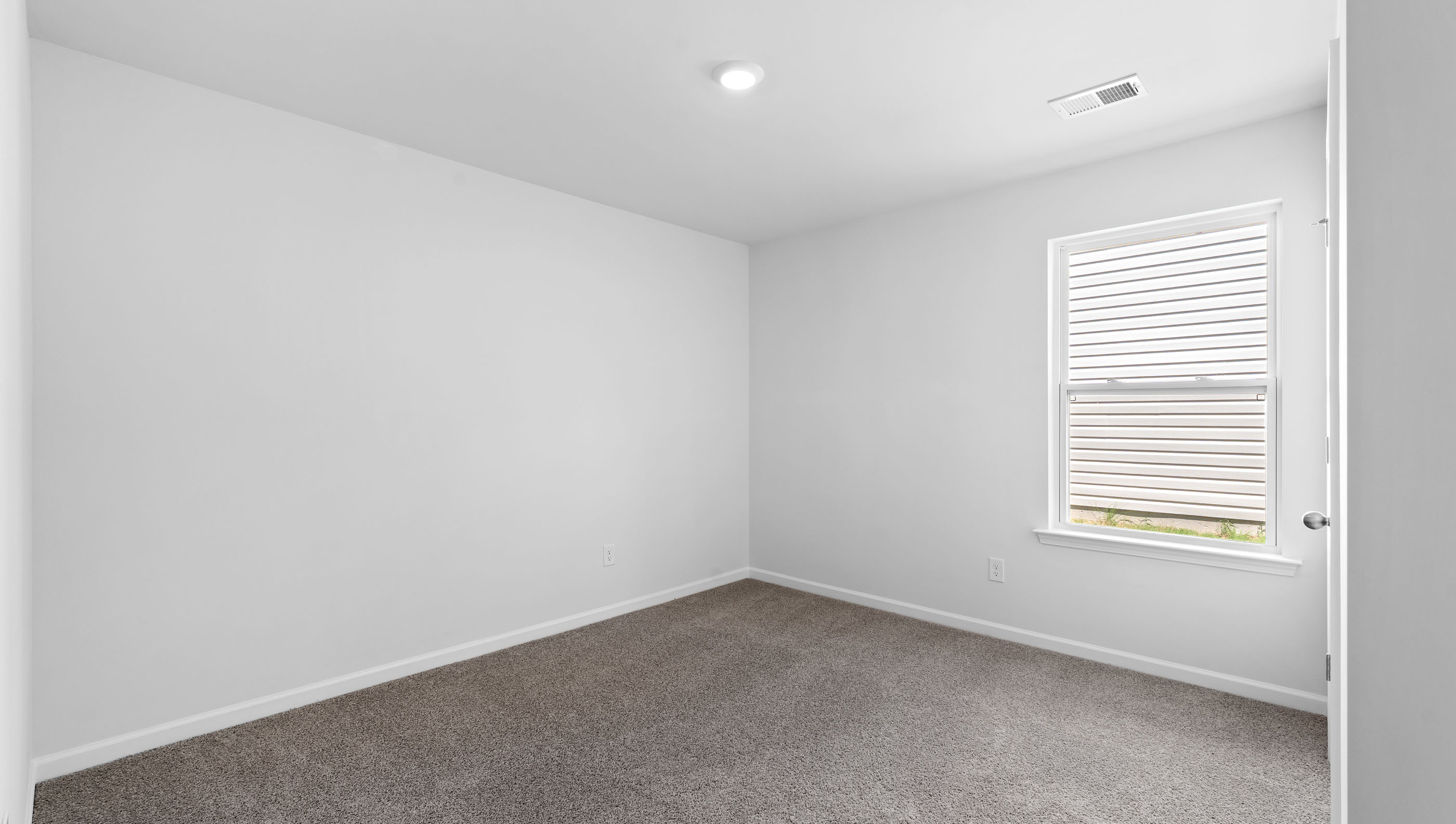 Bedroom with carpet and window.