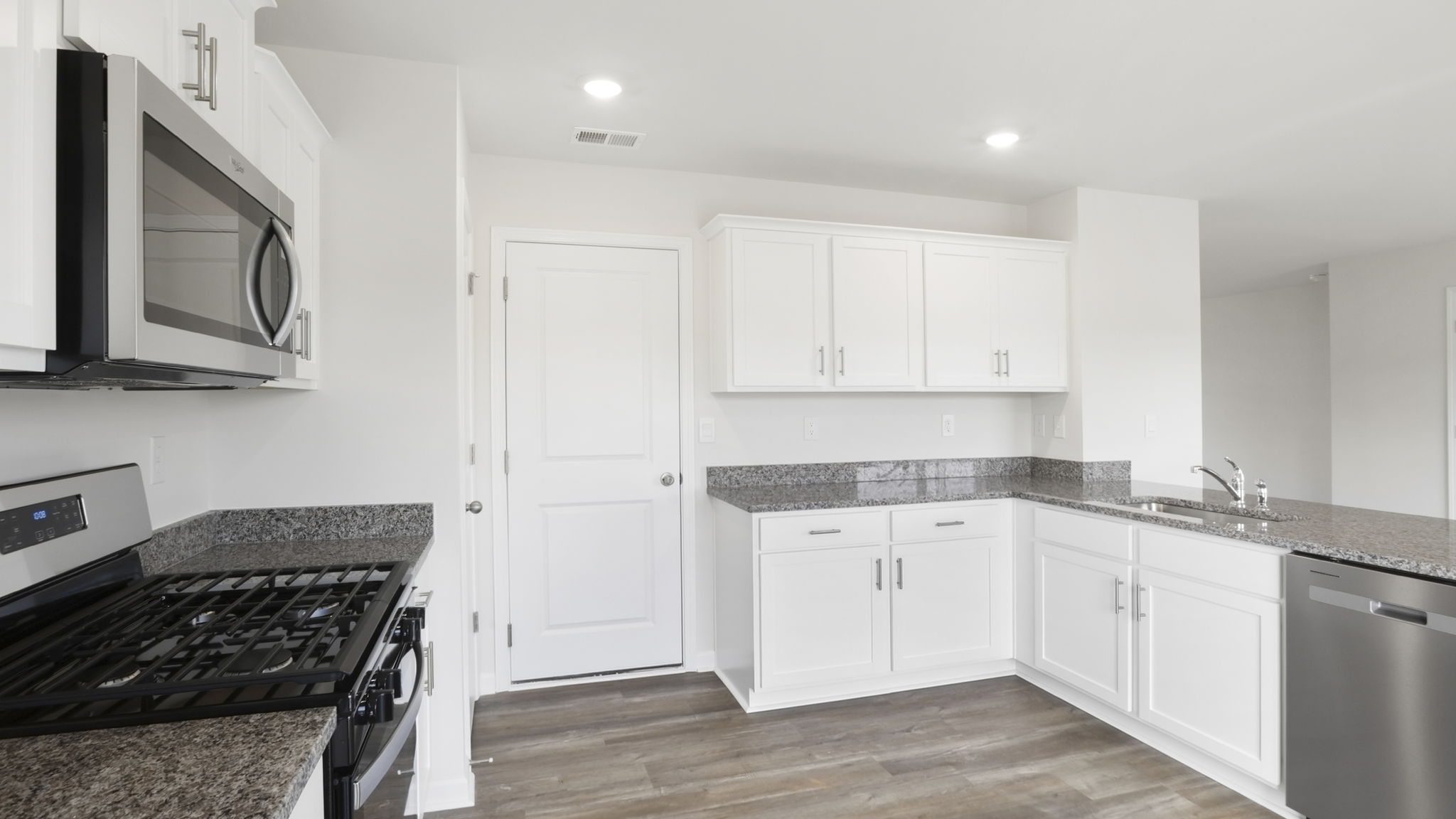 Kitchen with quartz countertops and stainless steel appliances.