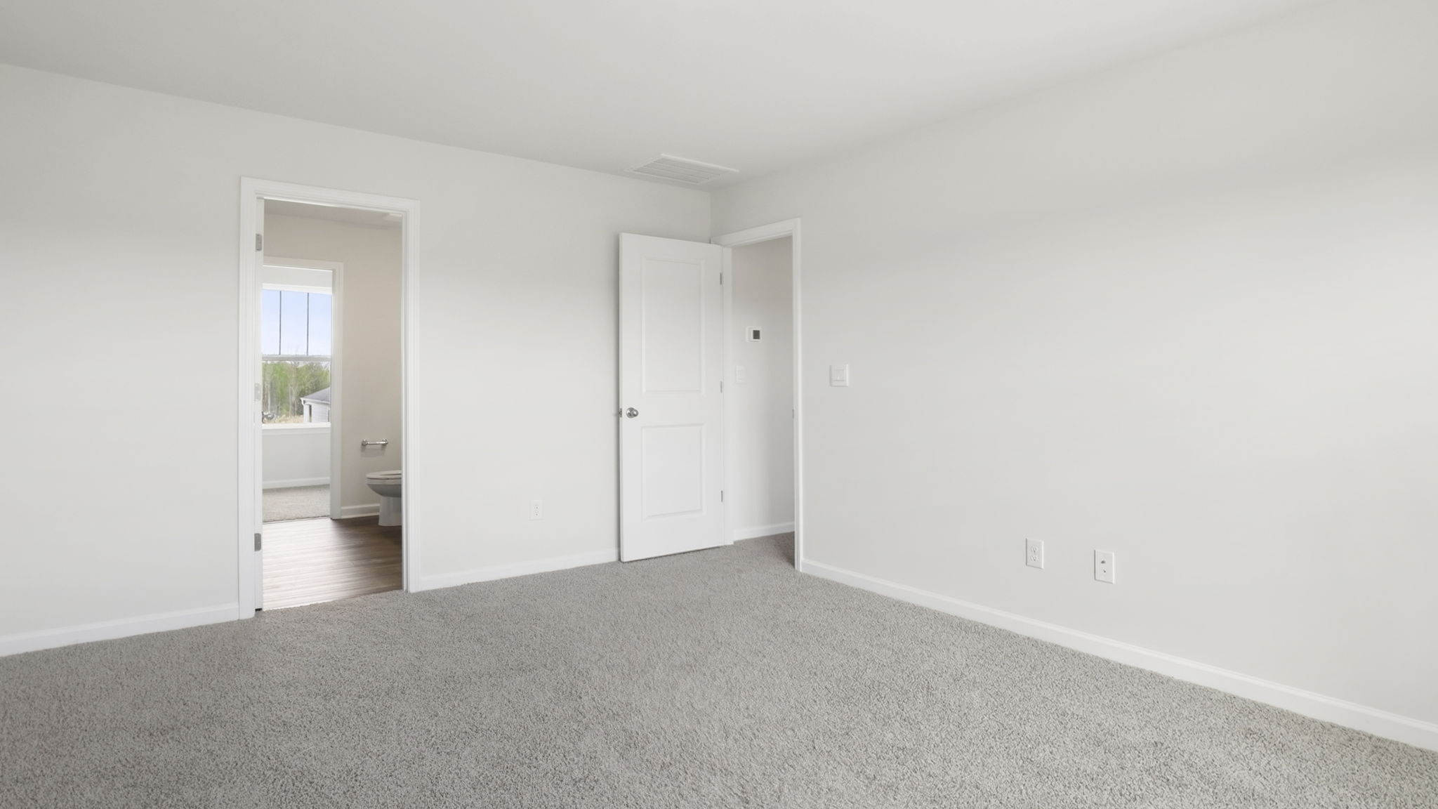 Bedroom with carpet and window.