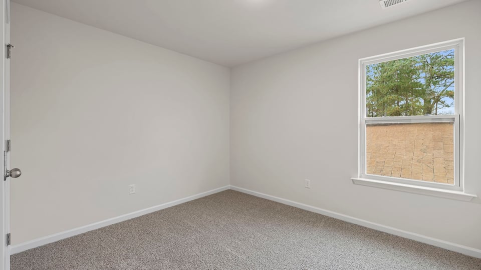 Bedroom with window and carpet.