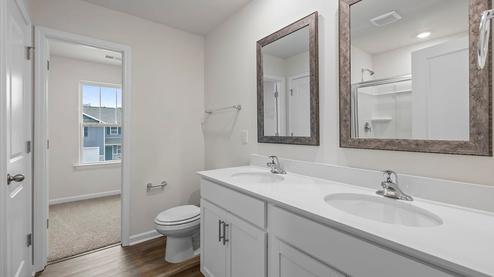 Primary bathroom with dual sink vanity and mirrors.