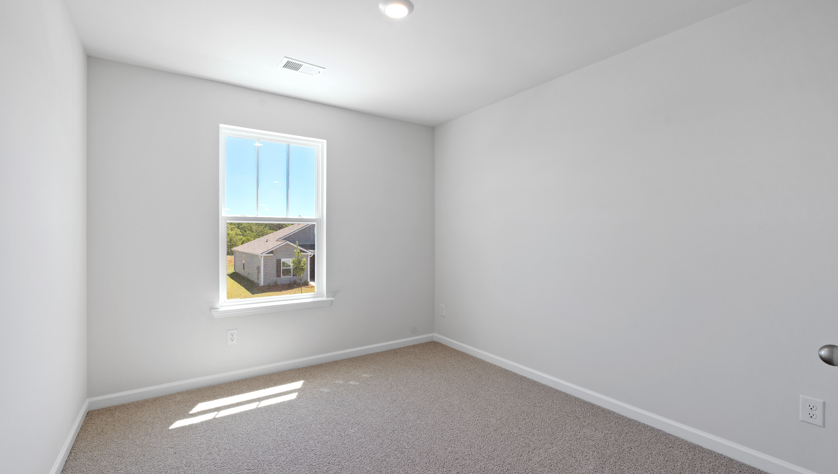 Bedroom with carpet and windows.