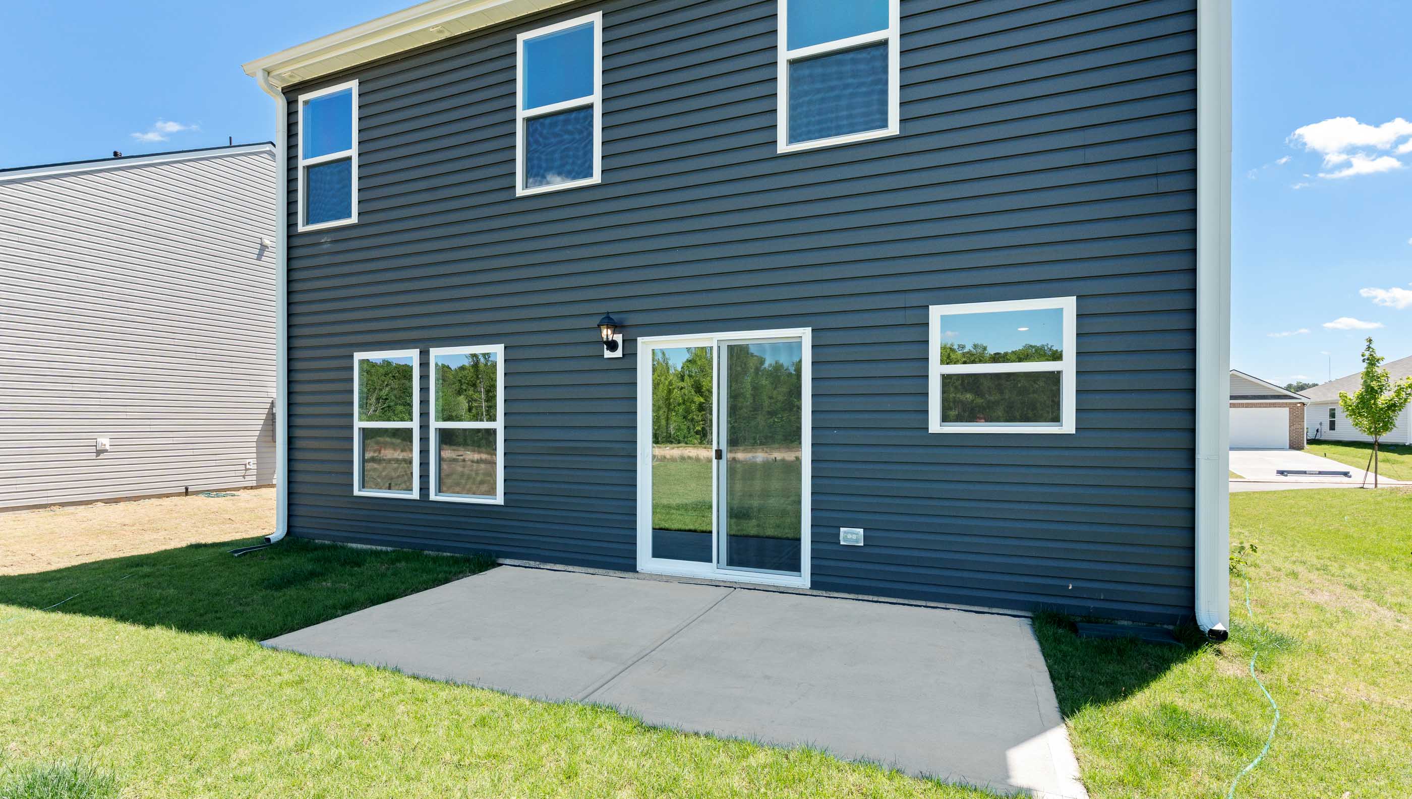 Rear view of home with small patio.