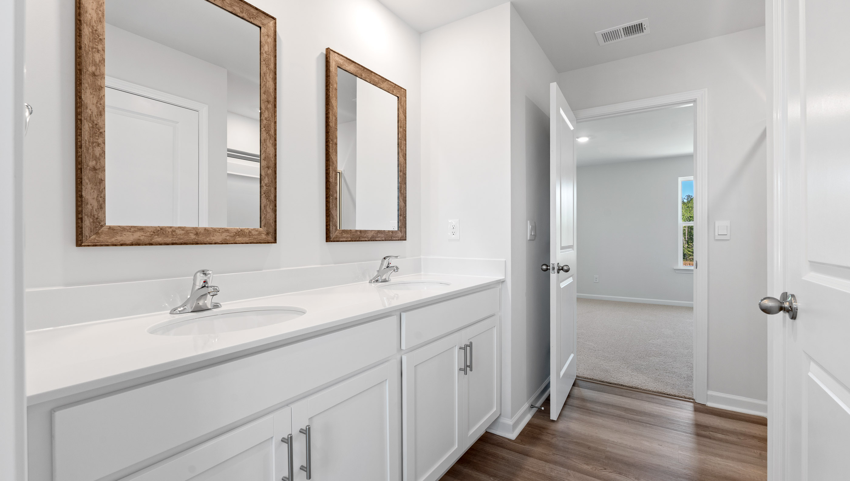 Bathroom with double vanity sink and walk in closet.