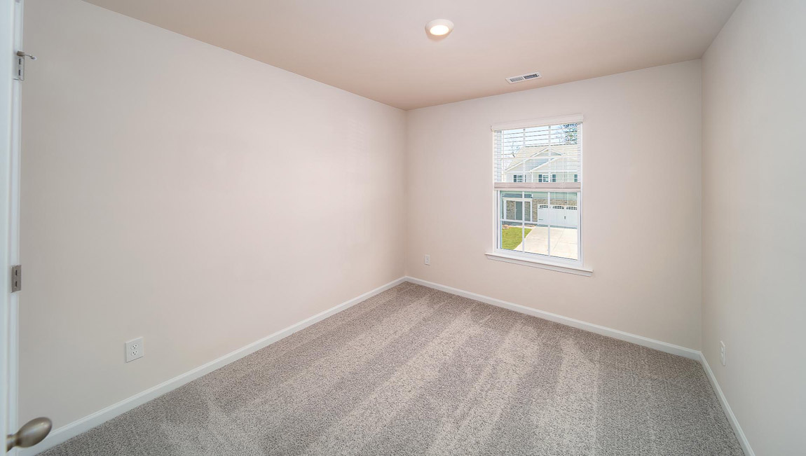 Bedroom with carpet and window.