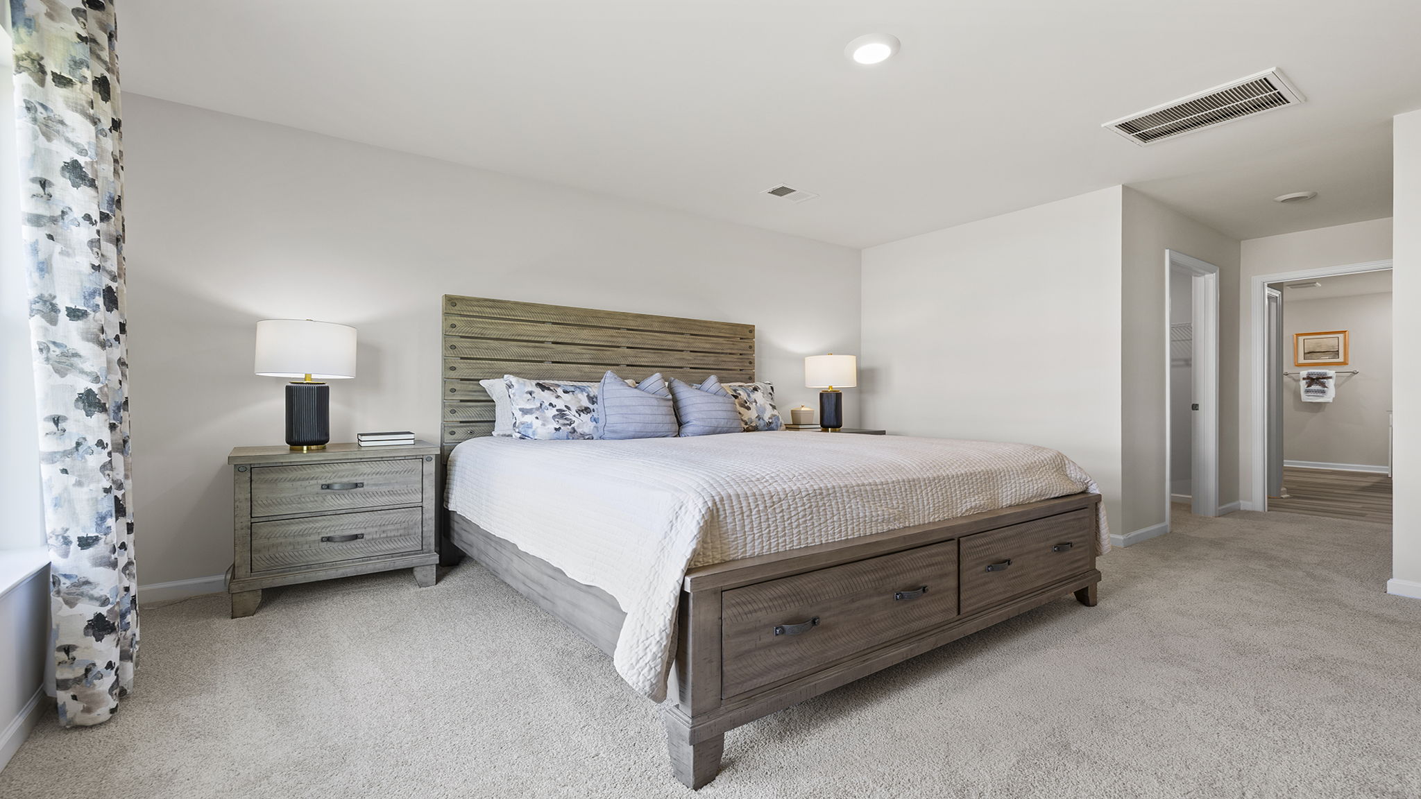 Primary bedroom with carpet and windows.