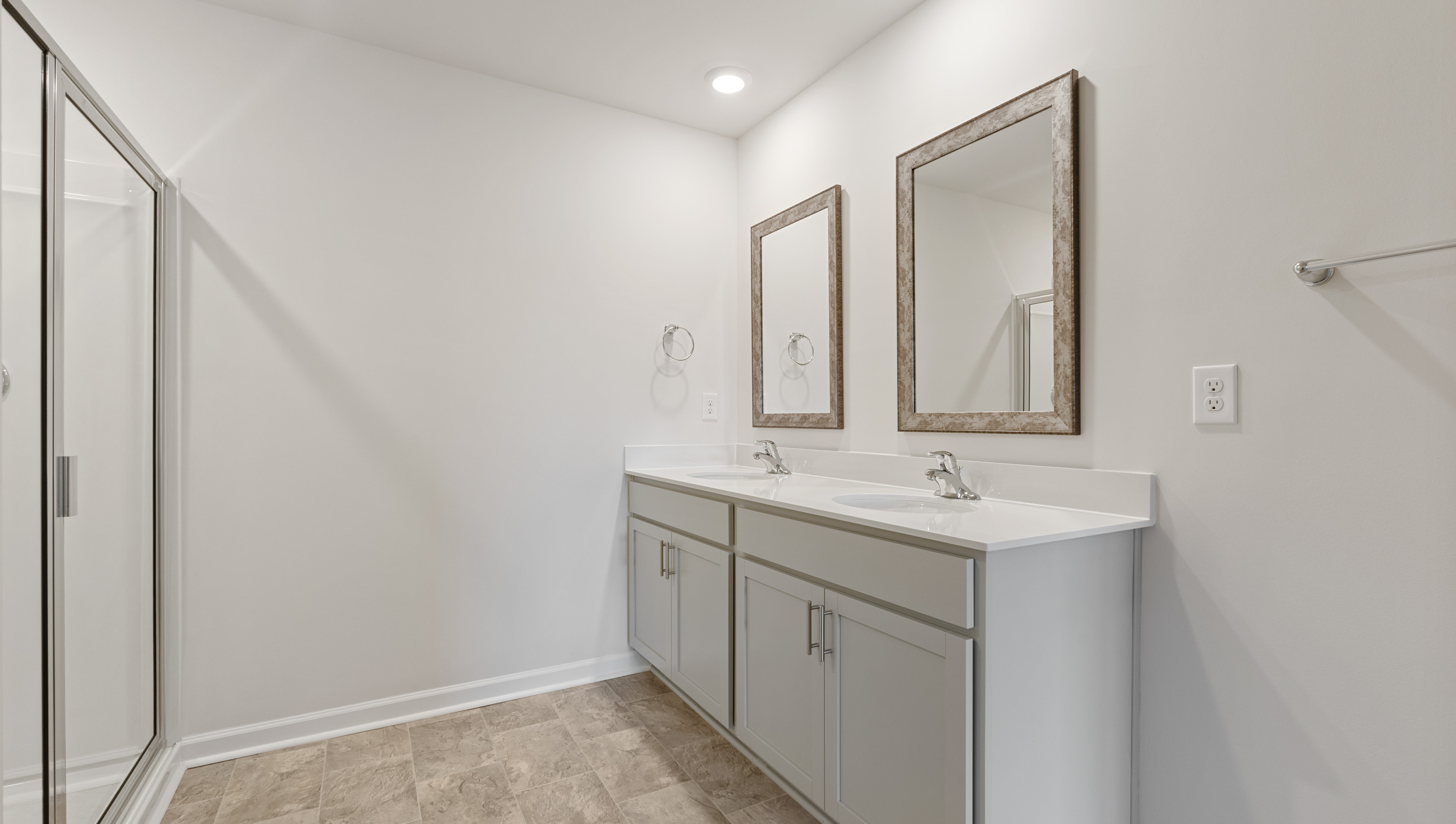 Primary bathroom with dual sink vanity and mirrors.