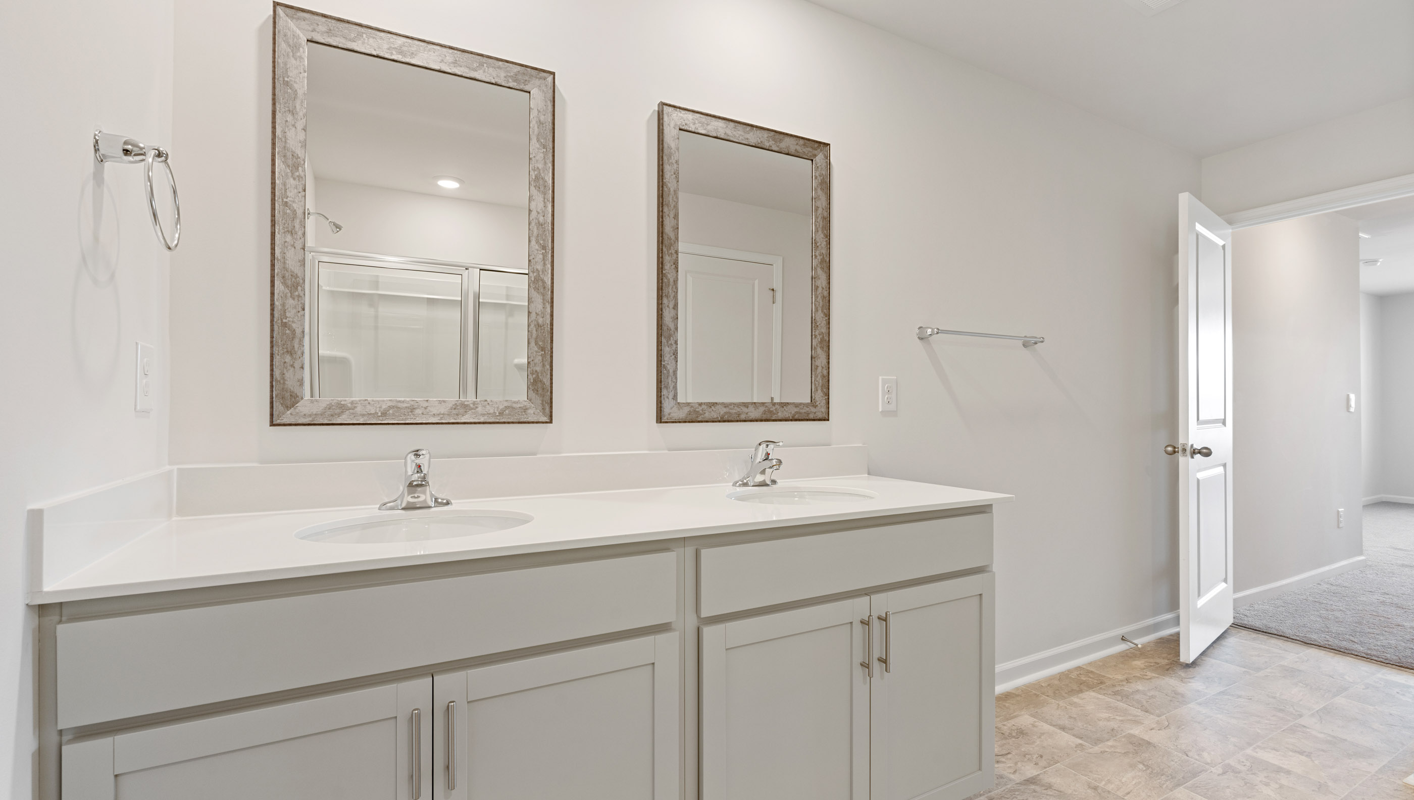 Primary bathroom with dual sink vanity and mirrors.