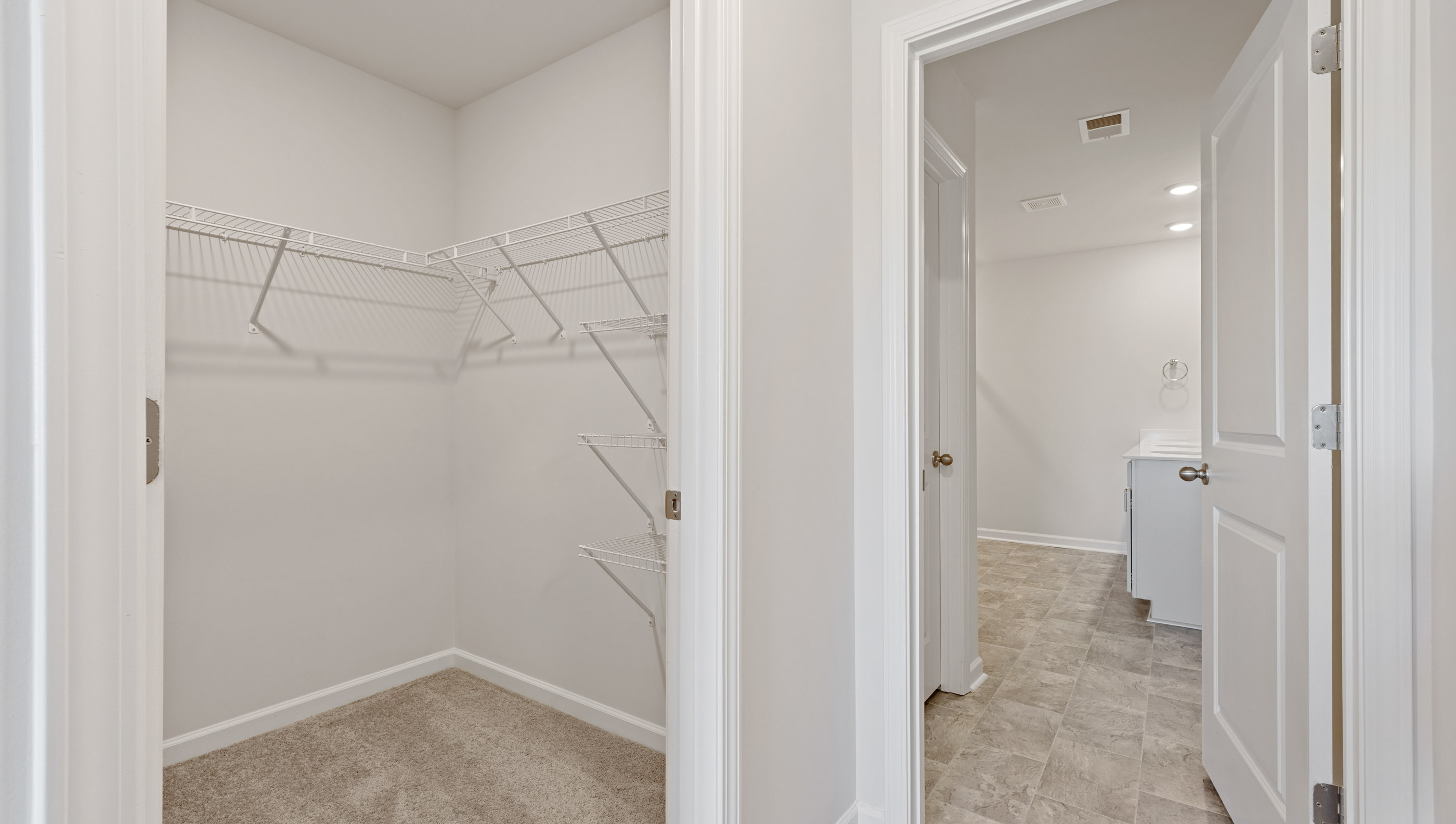 Primary walk-in closet and view of bathroom.
