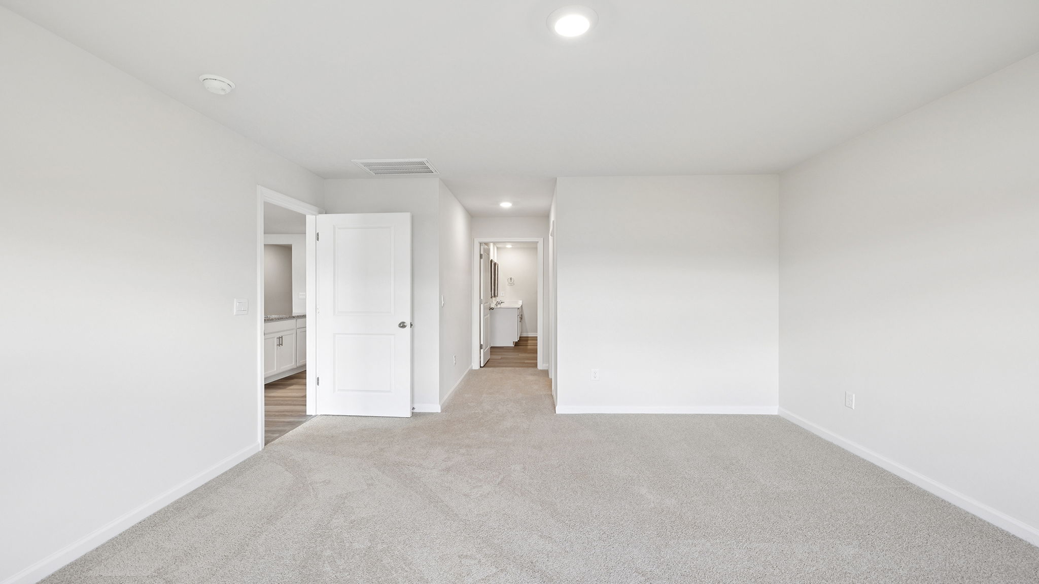 Primary bedroom with large window and carpet.