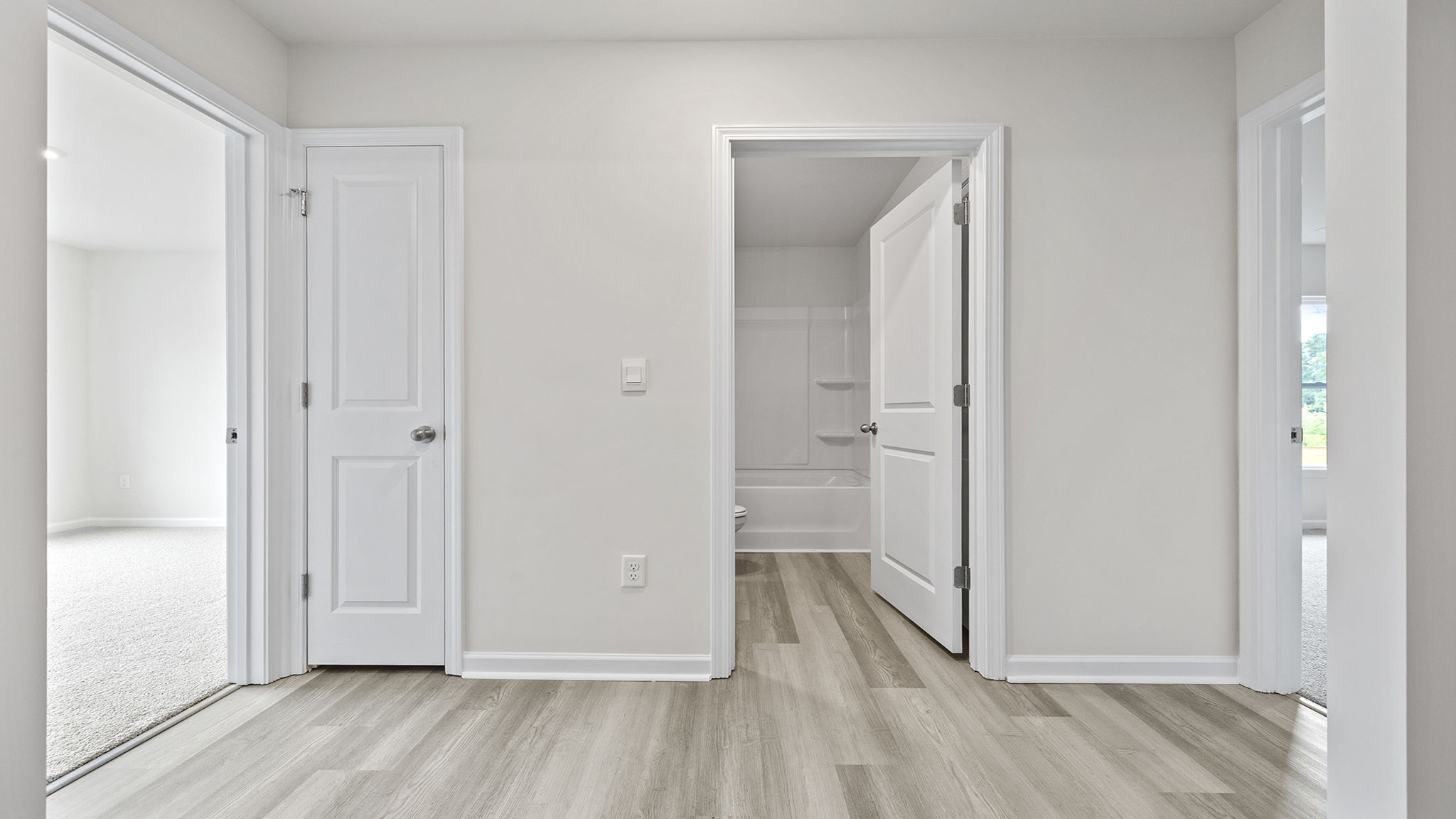 View of hallway and entrances to both bedrooms and hall bathroom.