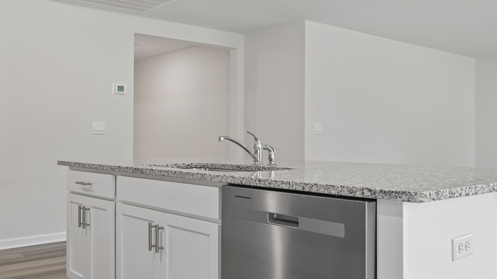 Kitchen island hosts the sink and dishwasher.